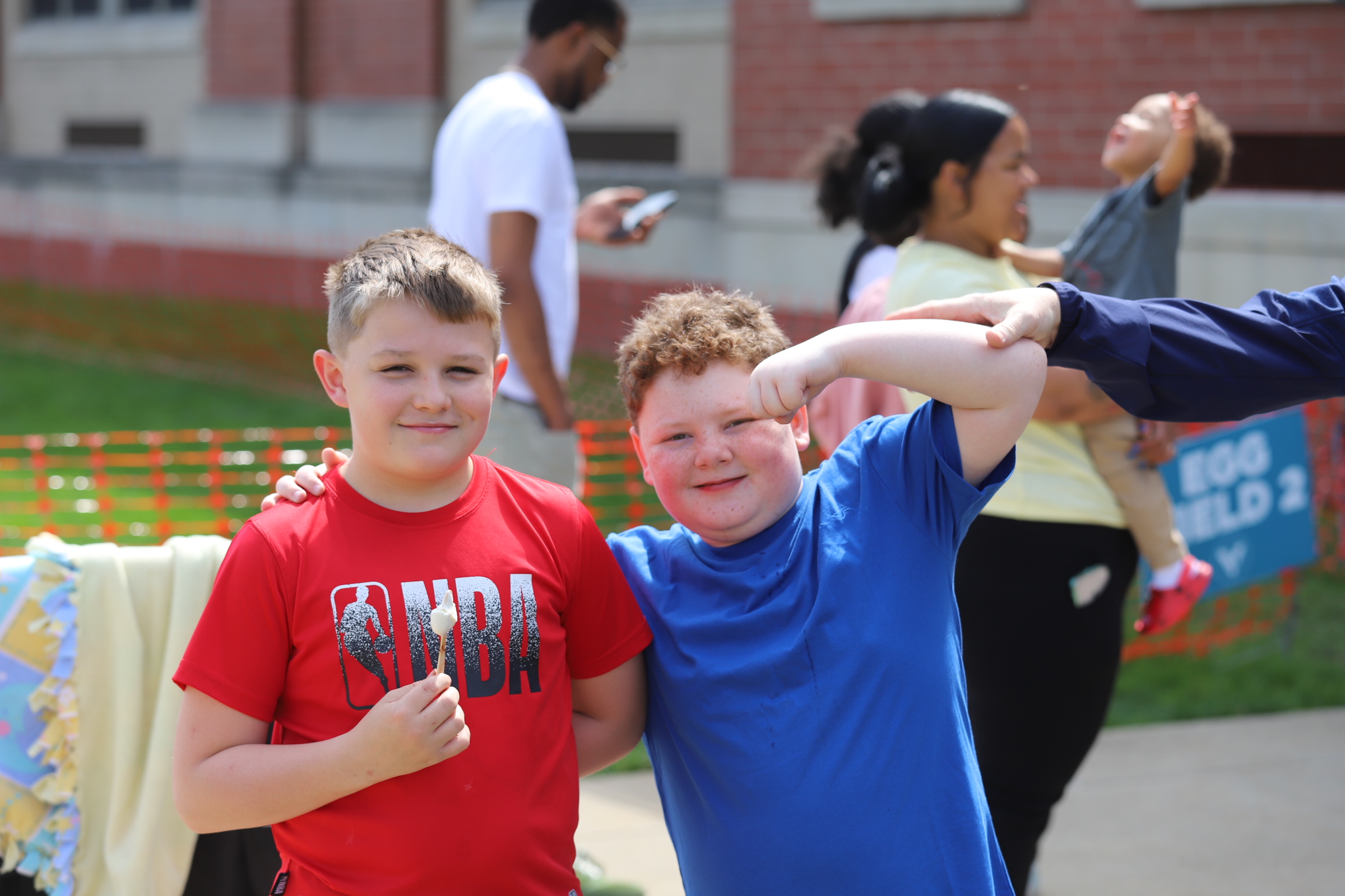 Two kids posing with person dressed up as Captain America at Eggstravaganza